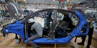 Workers on a car assembly line